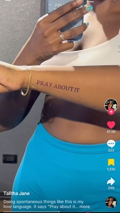 a woman holding a cell phone with the words pray about it tattooed on her arm