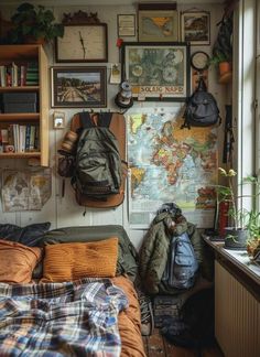 a bedroom with a map on the wall and backpacks hanging up against the wall