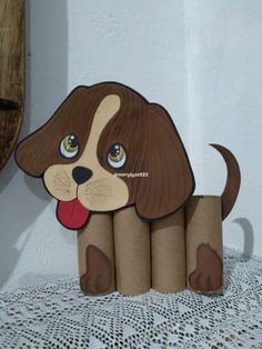 a cardboard dog sitting on top of a table next to some rolls of toilet paper