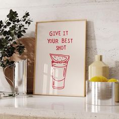 a framed poster that says give it your best shot next to some vases and lemons