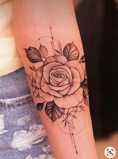 a woman's arm with a rose and arrow tattoo on the left side of her arm