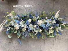 blue and white flowers are arranged on the wall