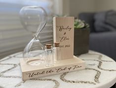 two bottles on a table with a wooden sign that says, wedding gifts for him and her