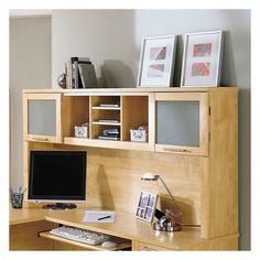 a desk with a computer monitor, keyboard and mouse next to bookshelves on the wall