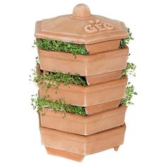 four clay planters stacked on top of each other with plants growing out of them