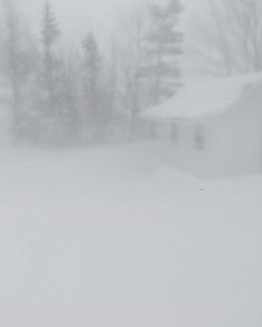 a man riding skis down a snow covered slope next to a building on a snowy day