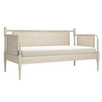 a white daybed sitting on top of a wooden floor