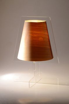 a lamp that is on top of a glass stand with a light in front of it