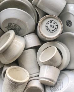 a pile of white cups and saucers sitting on top of each other