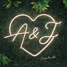 a neon sign that says love and is in the shape of a heart on top of a green wall