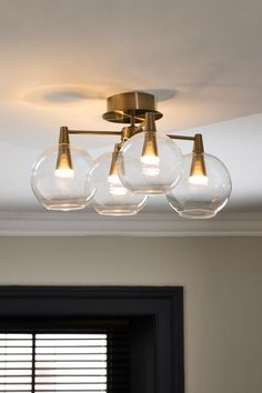 three clear globe lights hang from the ceiling