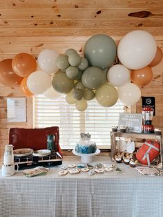 a table topped with lots of balloons next to a window