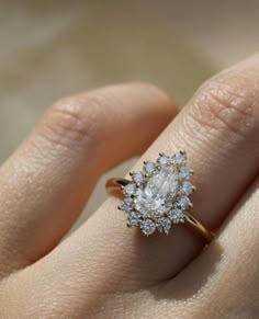 a woman's hand with a diamond ring on top of her finger and an engagement band