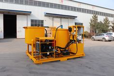 a yellow machine is parked in front of a building