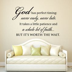 a white couch sitting in front of a wall with a quote on it