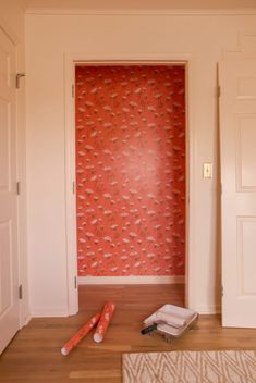 an open door in a room with red wallpaper