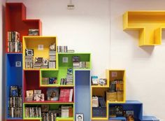 colorful bookshelves and shelves in a room with carpeted flooring on the ground