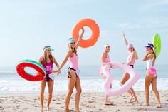 four girls on the beach holding inflatable rings