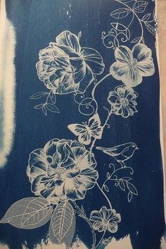 a blue and white drawing of flowers on a piece of paper that has been drawn