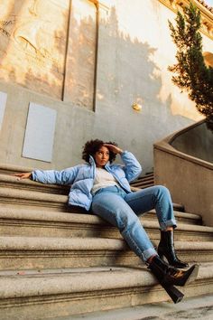 a woman sitting on some steps with her legs crossed