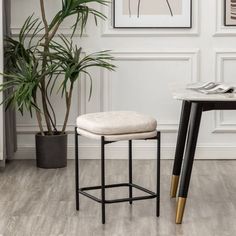 a table with a plant and two stools next to it