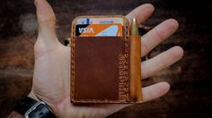 a hand holding an open wallet with a credit card slot in it's pocket