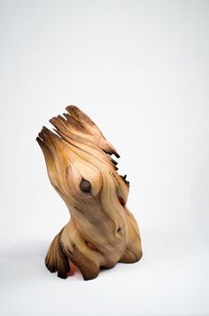 a wooden sculpture sitting on top of a white surface