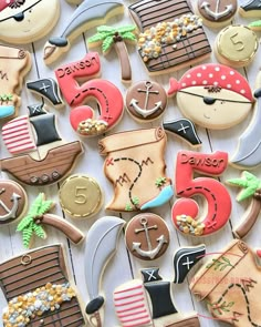 decorated cookies are arranged in the shape of boats, ships, and other things on display