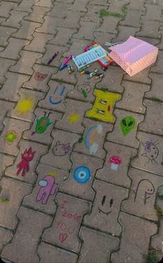 the sidewalk has been decorated with colorful drawings and crayons, including an umbrella