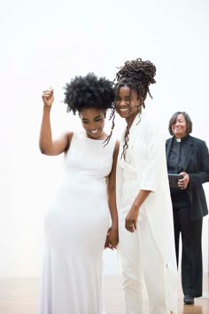 two women standing next to each other holding hands