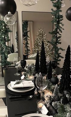 a dining room table decorated for christmas with black and white decorations