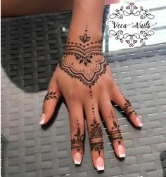 a woman's hand with henna tattoos on it