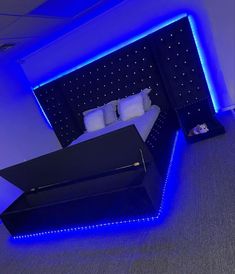 a bed with blue lights on the headboard and foot board in a room that is lit up