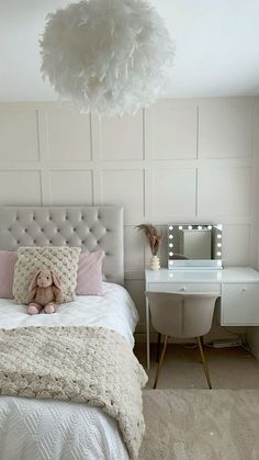 a bedroom with a bed, desk and mirror in the corner that has a teddy bear on it