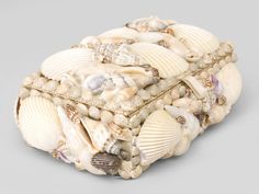 a box made out of seashells on a gray background