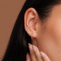 a close up of a woman's ear with two small gold stars on it