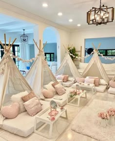 a living room filled with lots of pillows and teepees on top of white couches