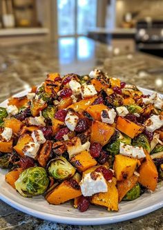 a white plate topped with brussel sprouts, butter and cranberries