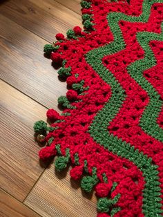 a red and green crocheted rug on the floor