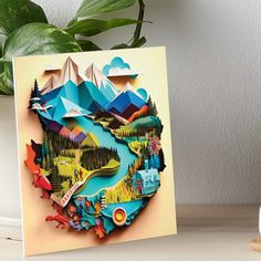 a paper cut out of the shape of a mountain with trees and mountains on it