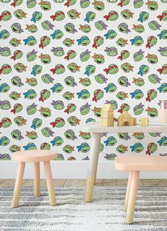 two children's tables and stools in front of a wall with colorful frogs on it