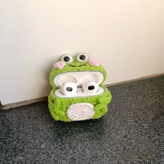 a green frog cell phone holder with two eyes