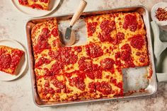 a square pizza sitting on top of a pan covered in cheese and pepperoni sauce