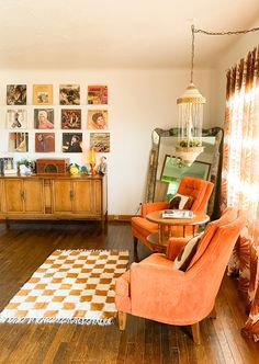 a living room with an orange chair and checkered rug in front of the window