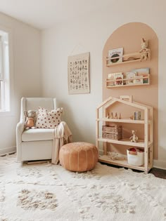 a child's room with pink walls and white carpet