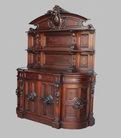 an old fashioned wooden cabinet with carvings on the top and bottom, against a gray background