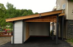 a garage with a carport attached to the side of it and an open door