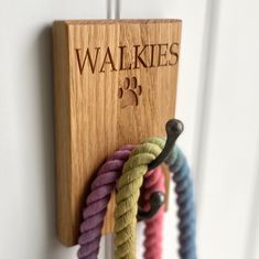 there is a wooden key holder with several ropes hanging from it's sides and the name walkies on it