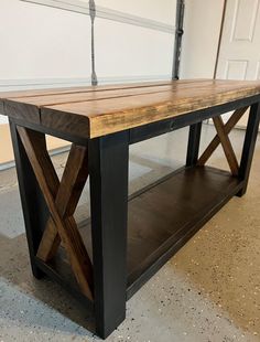 a wooden table sitting on top of a floor next to a white wall and door