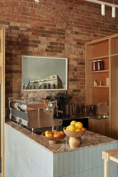 a kitchen counter with bowls of fruit on it and a coffee maker in the background